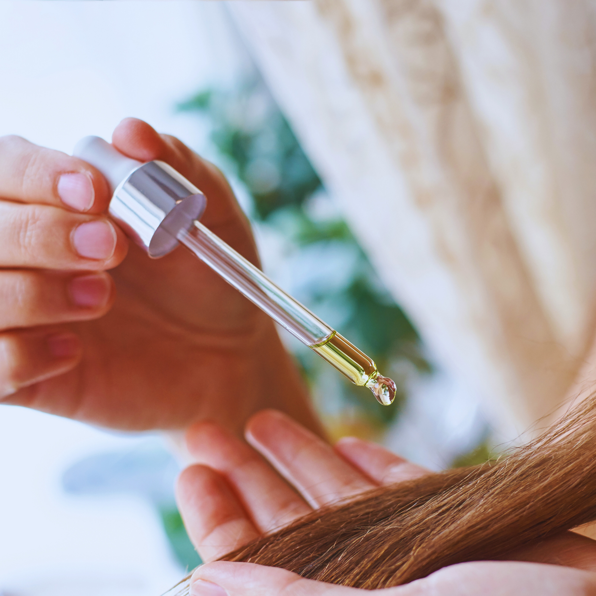 a woman oiling her hair with the Herbal Edge Onion Hair Oil