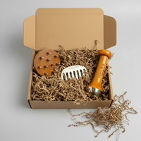 Three hair and skin grooming tools in a cardboard box with brown packing material on a light gray background