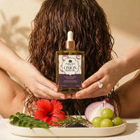 Person holding a bottle of onion hair oil with natural ingredients on a tray